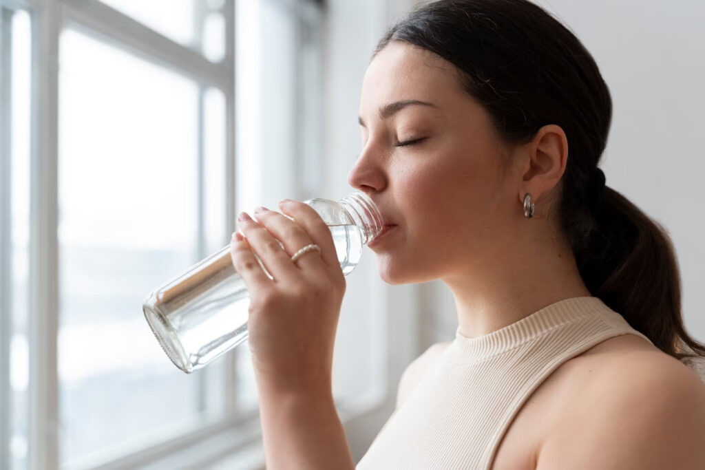A Woman Drinking Water on a Water Bottle